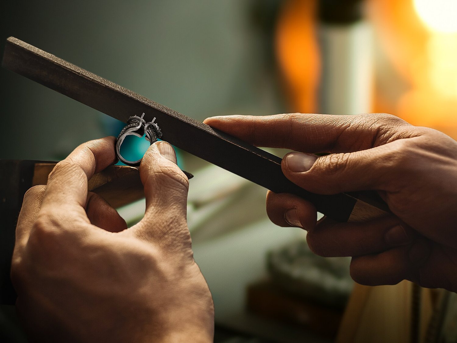 A jeweller filing a ring at the bench