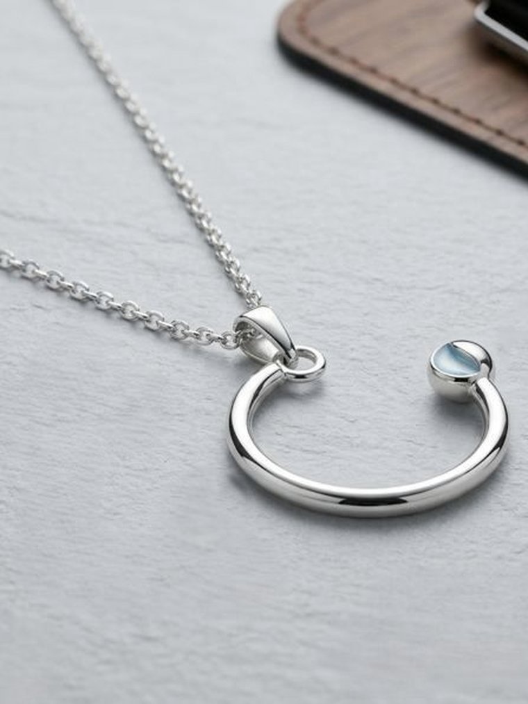 Minimal Argentium 960 silver pendant styled on a desk, the kind of piece boutiques stock
