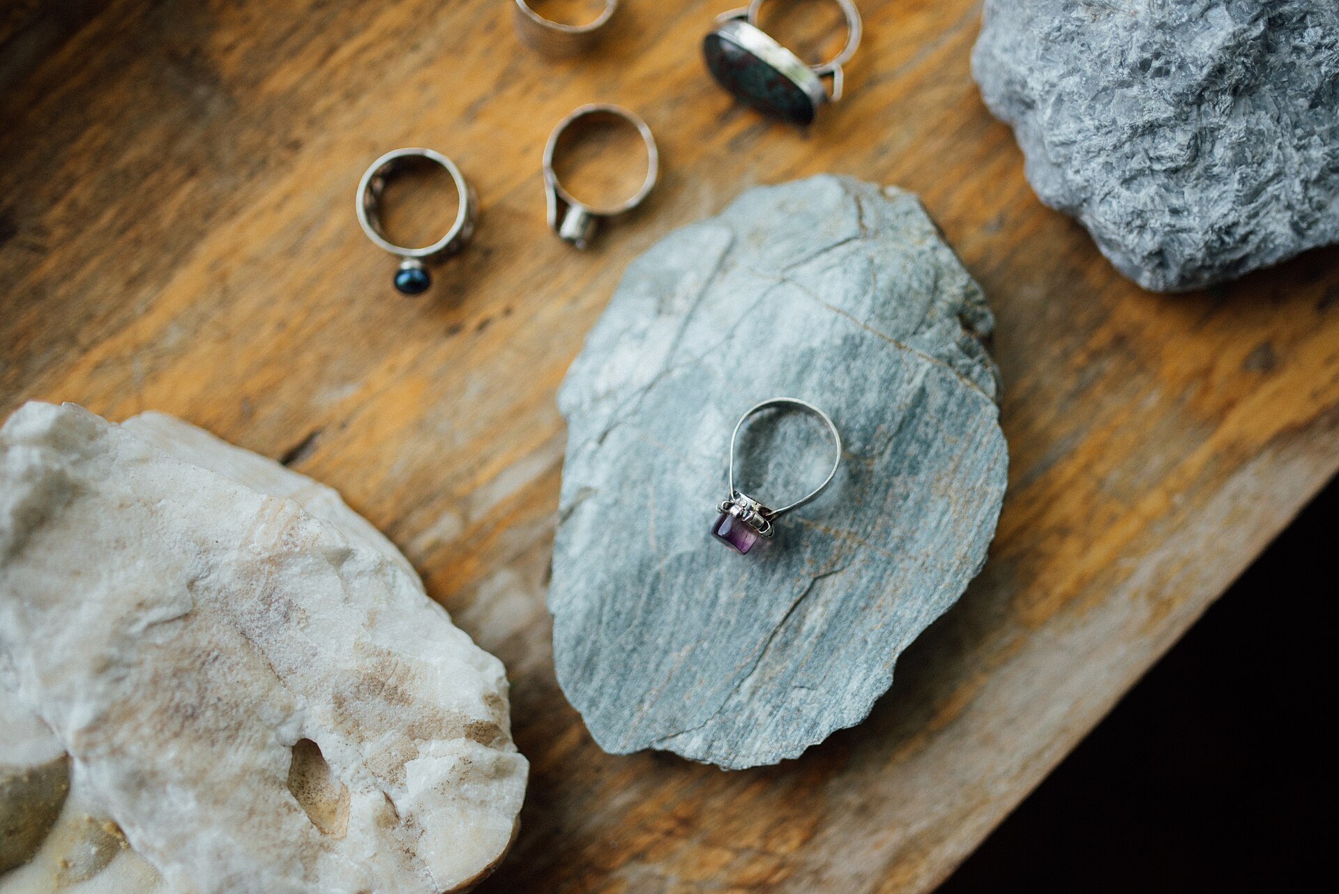 Silver rings with stones laid out on stone slabs
